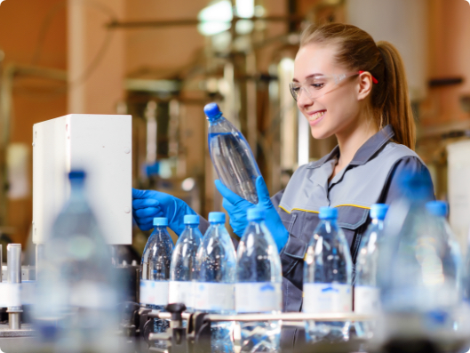 woman checking water bottles in factory